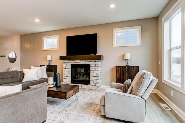 living room with a fireplace and light hardwood / wood-style flooring