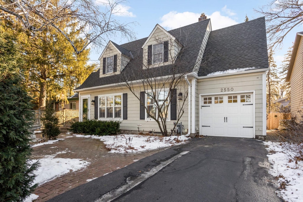 new england style home featuring a garage