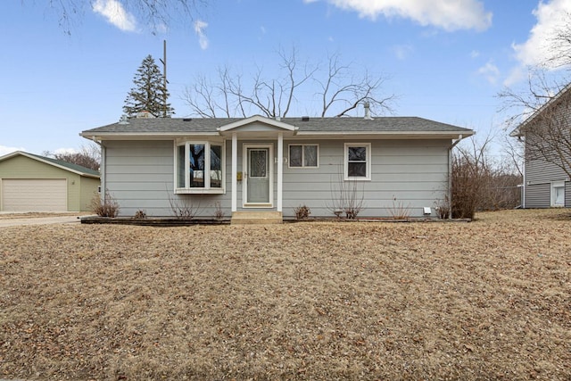 ranch-style home featuring a garage and an outbuilding