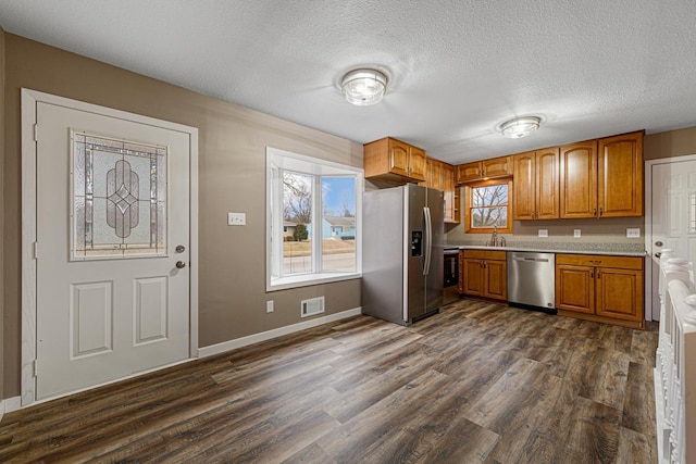 kitchen with sink, dark hardwood / wood-style floors, a textured ceiling, and appliances with stainless steel finishes