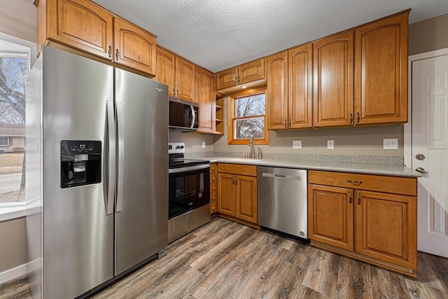 kitchen with dark hardwood / wood-style flooring, sink, a textured ceiling, and appliances with stainless steel finishes