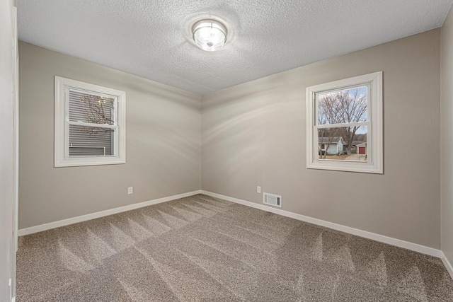 carpeted spare room featuring a textured ceiling