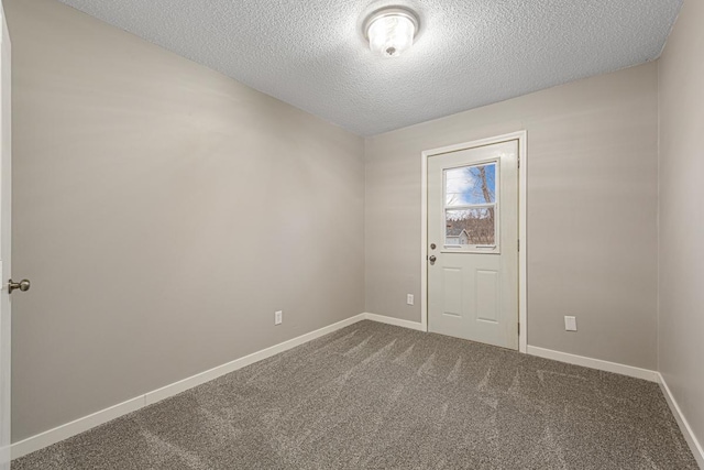 carpeted spare room with a textured ceiling