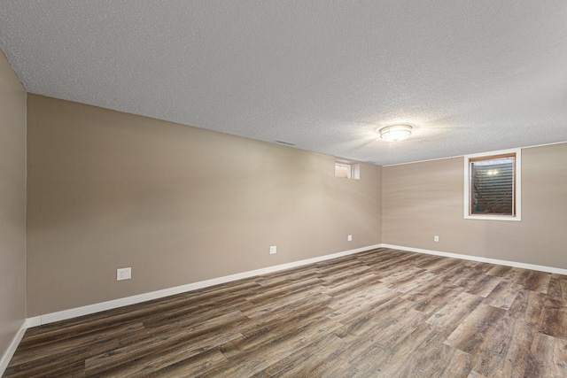 empty room with dark hardwood / wood-style floors and a textured ceiling