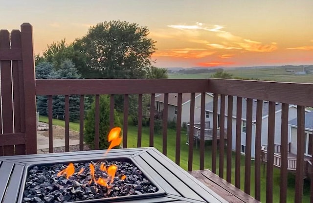 deck at dusk featuring a lawn and an outdoor fire pit