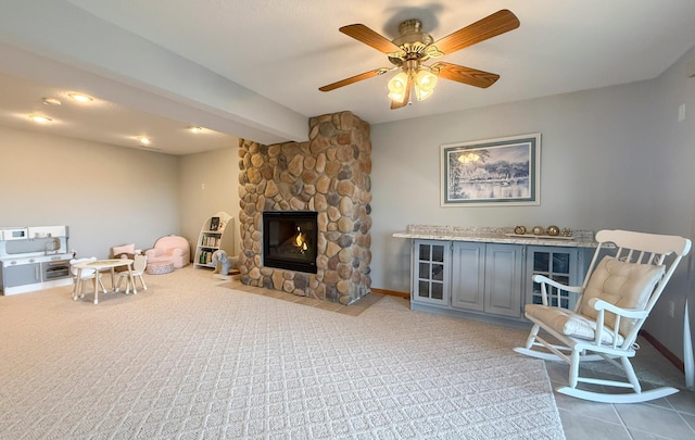 interior space with beam ceiling, a ceiling fan, carpet floors, a fireplace, and baseboards