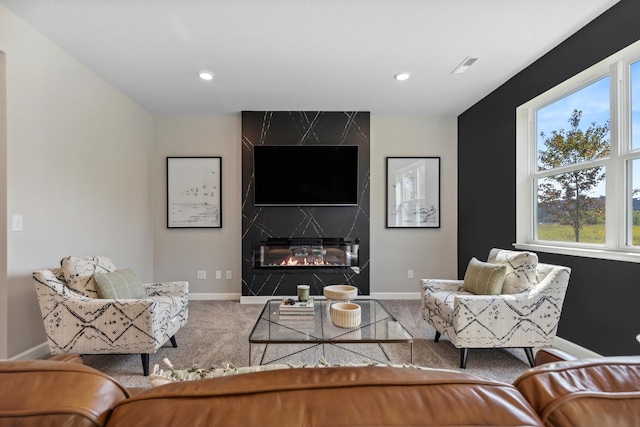 living room featuring a high end fireplace and carpet floors