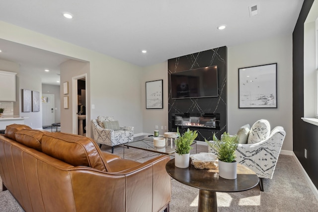 carpeted living room with a high end fireplace