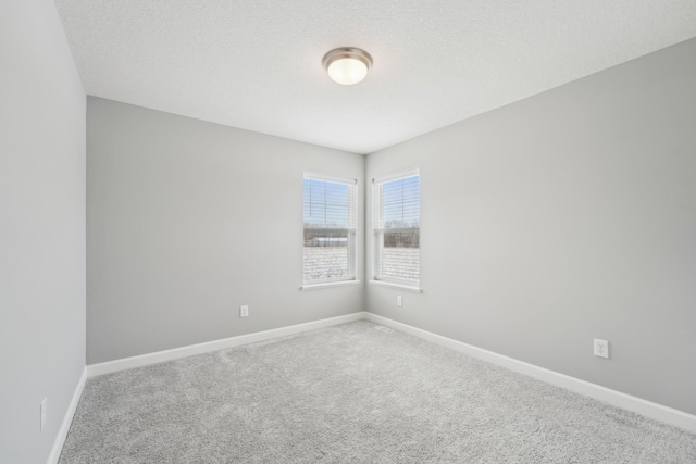 carpeted empty room featuring a textured ceiling