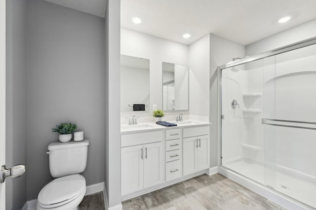 bathroom with toilet, wood-type flooring, vanity, and walk in shower