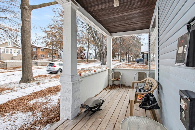 snow covered deck with a porch