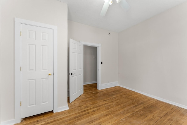 unfurnished bedroom featuring ceiling fan, light hardwood / wood-style floors, and a closet