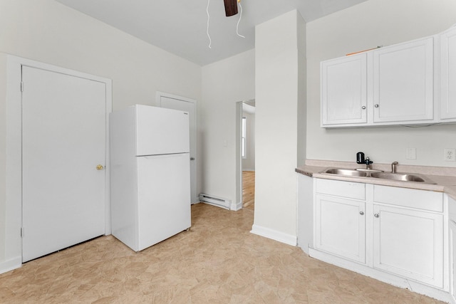 kitchen featuring baseboard heating, sink, white cabinets, and white refrigerator