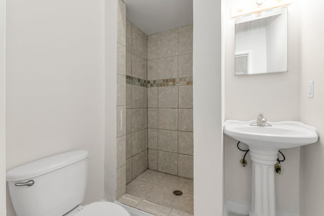 bathroom with tiled shower and toilet