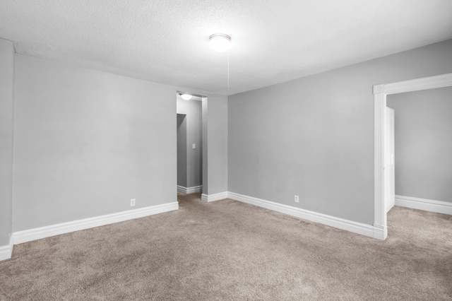 carpeted empty room with a textured ceiling