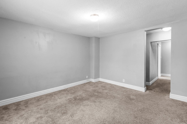 carpeted empty room featuring a textured ceiling