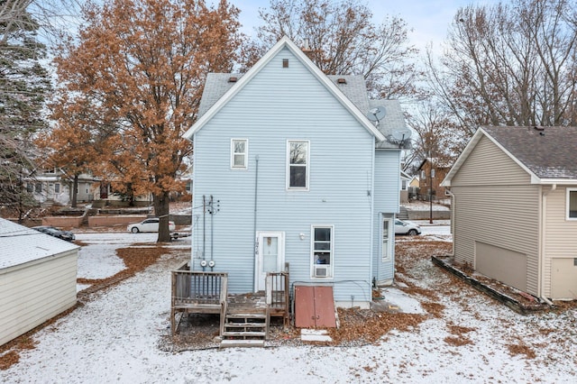 snow covered rear of property with a wooden deck