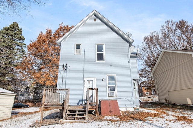 snow covered rear of property with a wooden deck