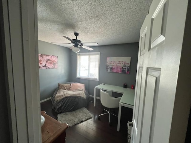 bedroom featuring dark wood-type flooring, a textured ceiling, and ceiling fan