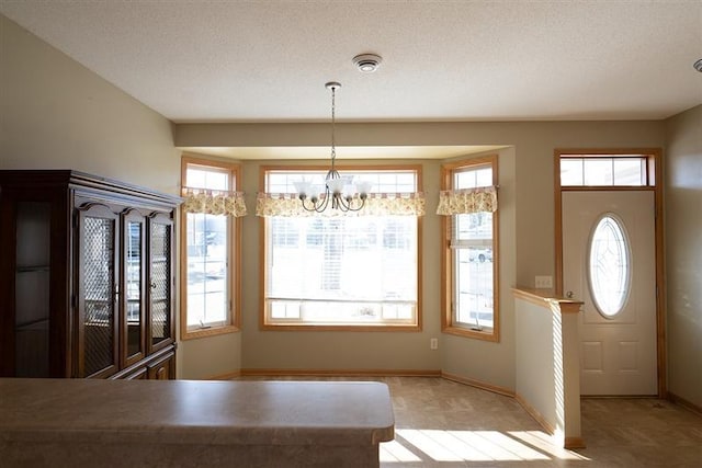 unfurnished dining area with a textured ceiling and a chandelier