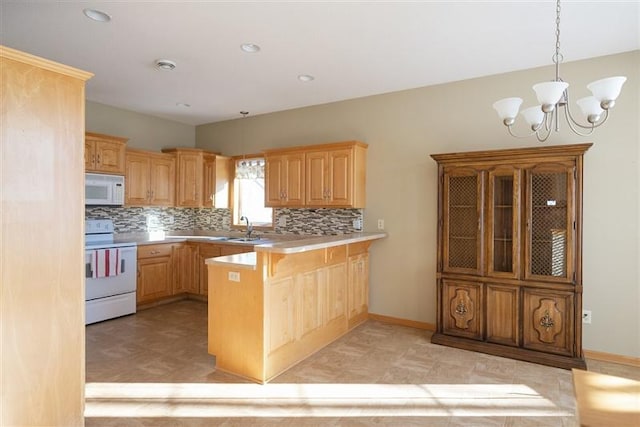 kitchen featuring decorative light fixtures, sink, a chandelier, kitchen peninsula, and white appliances