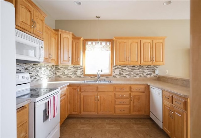 kitchen featuring sink, light brown cabinets, white appliances, and decorative light fixtures