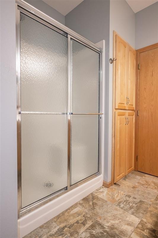 bathroom featuring a shower with shower door