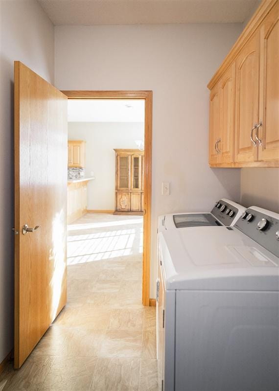 laundry room featuring cabinets and washing machine and clothes dryer