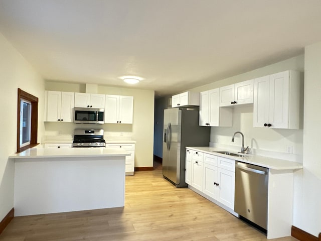 kitchen featuring white cabinetry, appliances with stainless steel finishes, sink, and light hardwood / wood-style floors