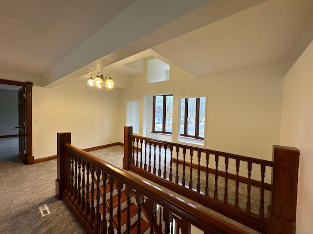 hallway with a notable chandelier and carpet