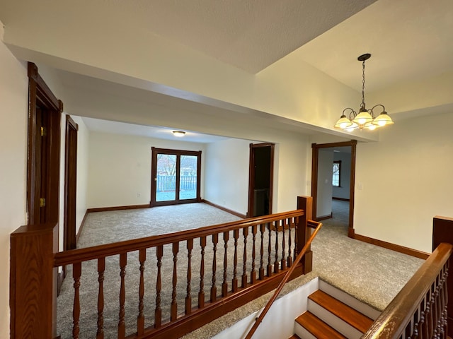 staircase with carpet and a chandelier