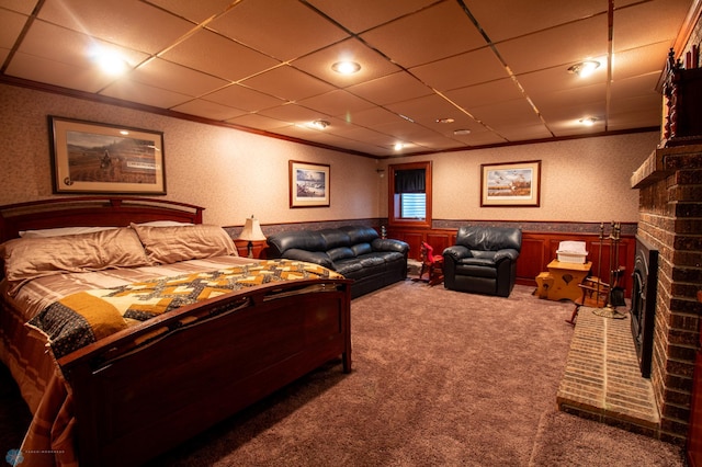 bedroom with crown molding, carpet, and a brick fireplace