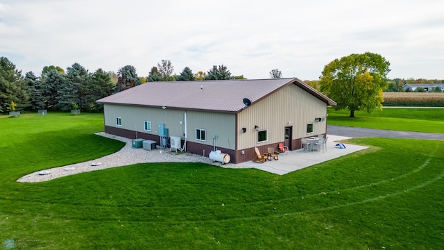 rear view of house featuring a lawn, a patio, and central air condition unit