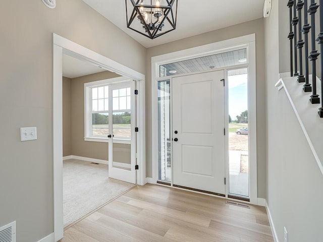 entryway featuring a wealth of natural light, light hardwood / wood-style flooring, and a chandelier