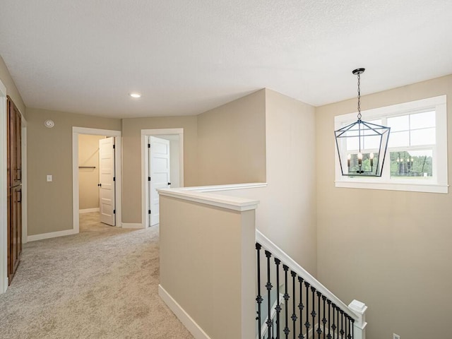 corridor featuring light colored carpet