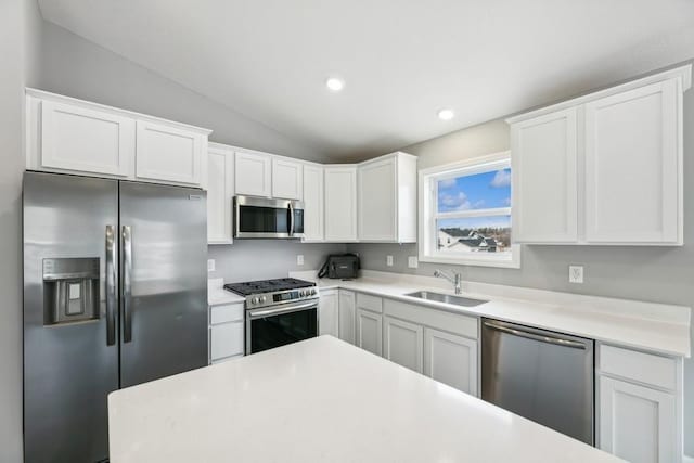 kitchen with sink, vaulted ceiling, stainless steel appliances, and white cabinets