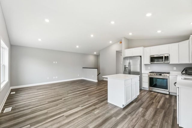 kitchen featuring white cabinetry, dark hardwood / wood-style flooring, a center island, and appliances with stainless steel finishes