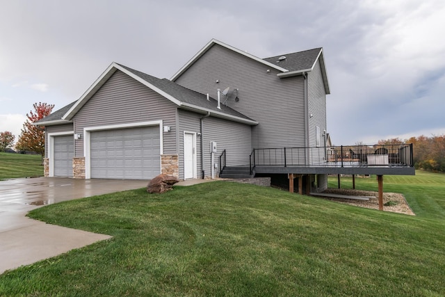 exterior space featuring a wooden deck, a garage, and a lawn