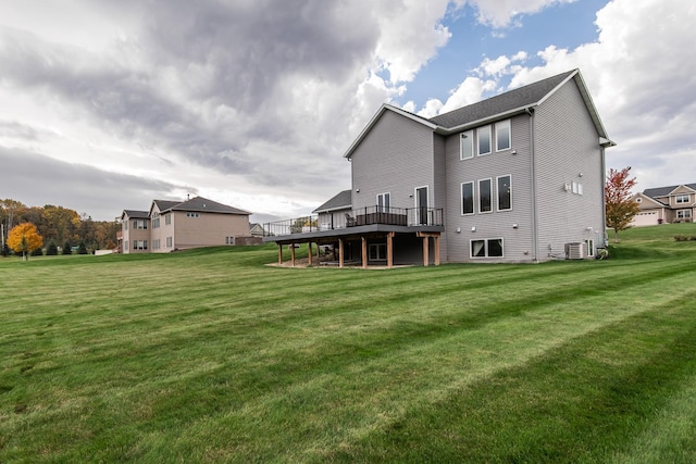 rear view of house with central AC, a lawn, and a deck