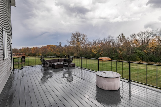 wooden deck with a lawn and an outdoor living space with a fire pit