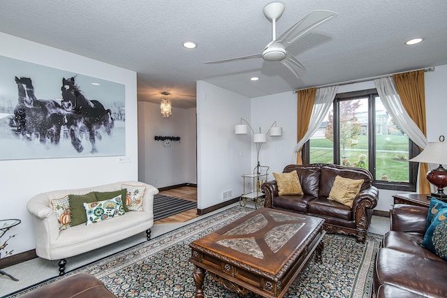 living room featuring ceiling fan and a textured ceiling