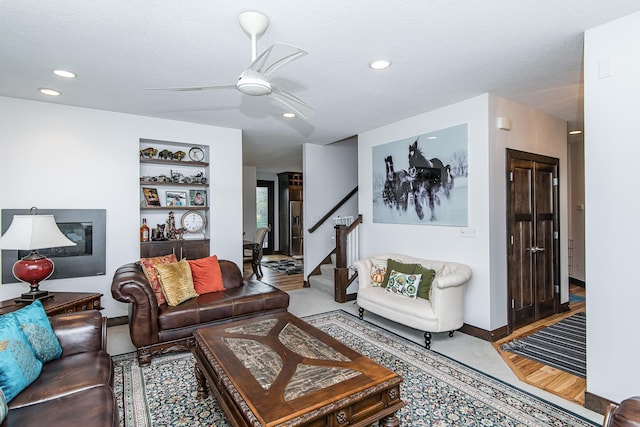 living room with a textured ceiling and ceiling fan