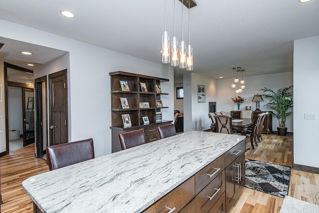 dining area featuring a chandelier, a textured ceiling, and light hardwood / wood-style floors