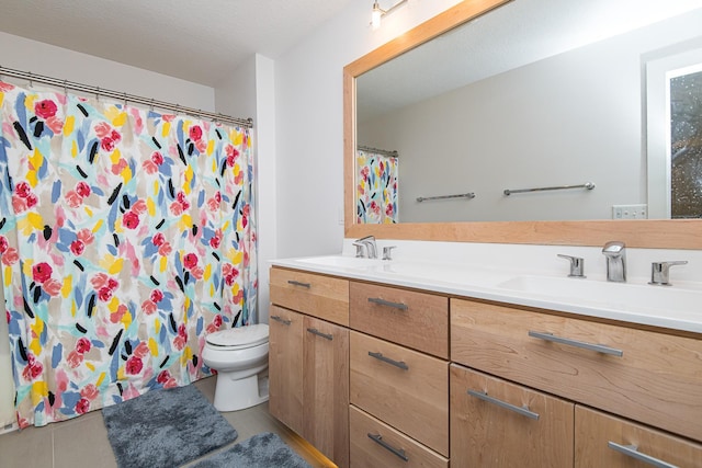 bathroom featuring tile patterned flooring, vanity, curtained shower, and toilet