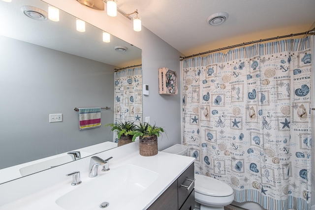 bathroom featuring walk in shower, vanity, and toilet