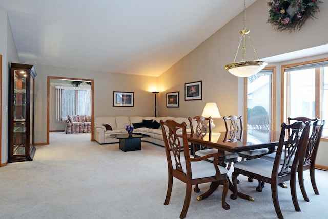 dining space featuring light carpet and high vaulted ceiling