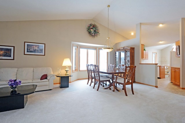 dining area with light carpet and vaulted ceiling