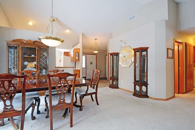 carpeted dining space featuring lofted ceiling