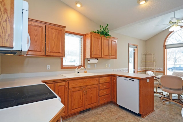 kitchen featuring sink, white appliances, ceiling fan, vaulted ceiling, and kitchen peninsula