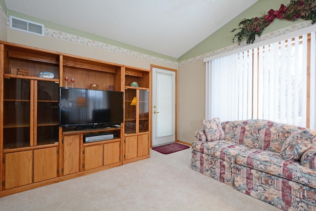 carpeted living room featuring vaulted ceiling